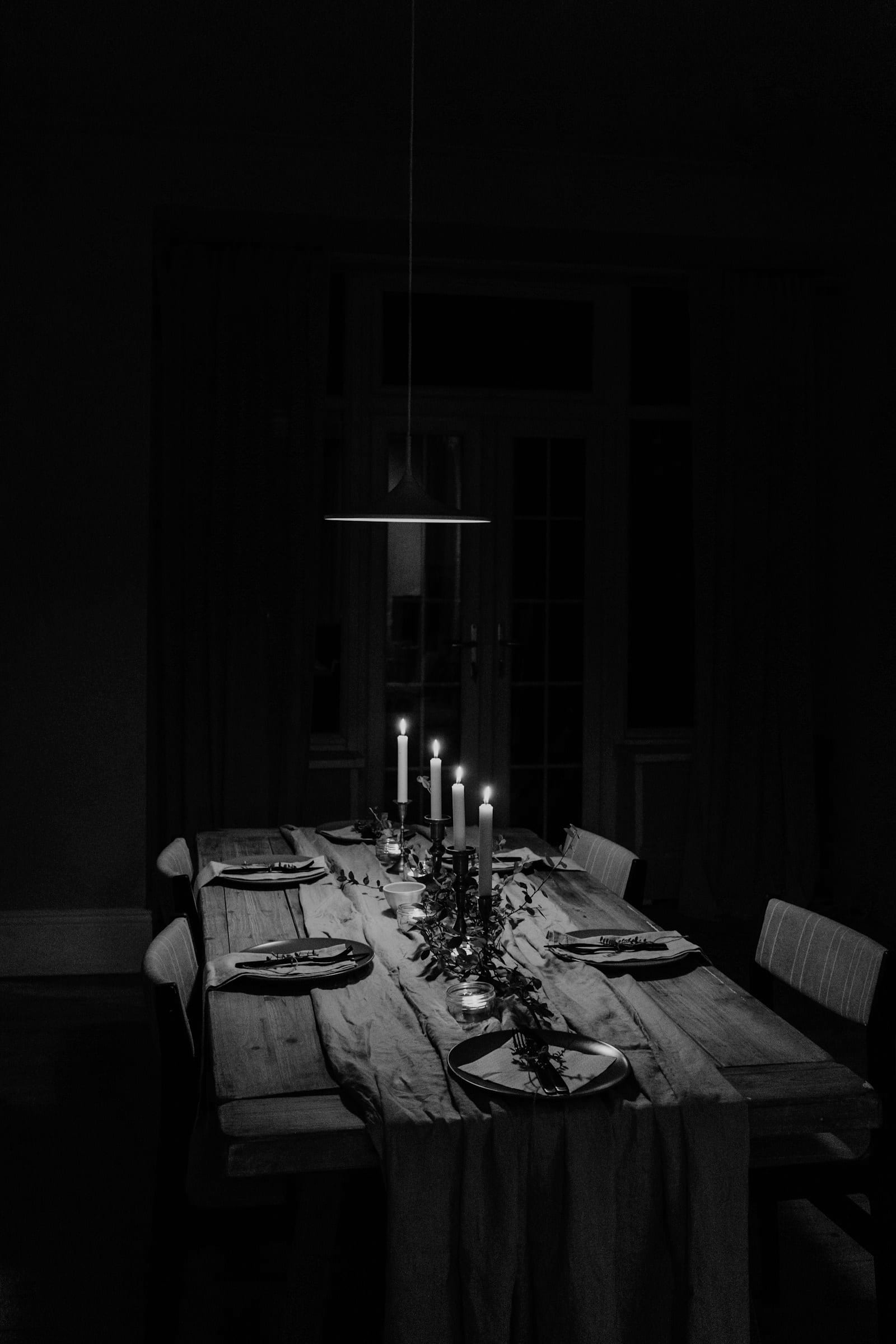 Long candlelit dinner table styled for a celebration
